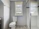 Bathroom featuring a shower with white subway tile, a window and toilet with gray walls at 1504 Indiana Ave, St Cloud, FL 34769