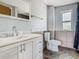 Bathroom featuring a modern vanity, toilet, tile accents, and natural light from the window at 1504 Indiana Ave, St Cloud, FL 34769