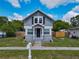 Charming two-story home featuring a covered entryway, gray siding, manicured lawn and a fenced backyard at 1504 Indiana Ave, St Cloud, FL 34769