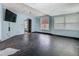 Bright living room with hardwood floors, a television, and multiple windows offering ample natural light at 1504 Indiana Ave, St Cloud, FL 34769