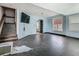 An empty living room featuring hardwood floors, a staircase, and natural light through the windows at 1504 Indiana Ave, St Cloud, FL 34769