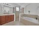 This bright bathroom offers a soaking tub, glass shower, and a large vanity with a big mirror at 1560 Canopy Pasture Dr, St Cloud, FL 34771