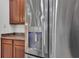 Stainless steel refrigerator featuring a water dispenser, next to wooden kitchen cabinets at 1560 Canopy Pasture Dr, St Cloud, FL 34771