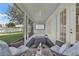 Neutral color tones and inviting furniture create a relaxing atmosphere on the screened-in patio with backyard views at 1560 Canopy Pasture Dr, St Cloud, FL 34771