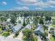 Aerial view of a quiet residential street with houses that overlook a tranquil lake surrounded by lush trees at 172 Clear Lake Cir, Sanford, FL 32773