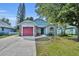 Charming single-story home with a well-manicured lawn, mature trees, and a driveway leading to the garage at 172 Clear Lake Cir, Sanford, FL 32773
