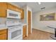 Kitchen featuring white appliances, wood cabinets, and breakfast table at 172 Clear Lake Cir, Sanford, FL 32773