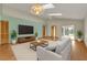 Rendered living room with contemporary sofa, plants, television and wood flooring at 172 Clear Lake Cir, Sanford, FL 32773