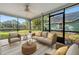 Staged sunroom features comfortable seating and views of the backyard and waterfront at 172 Clear Lake Cir, Sanford, FL 32773