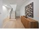 Bright hallway with wood floors, white walls, decorative cabinet, and staircase at 1760 Mondrian Cir, Winter Park, FL 32789