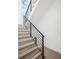 Modern staircase features wooden treads, black metal railing, and natural light from a nearby window at 1760 Mondrian Cir, Winter Park, FL 32789