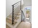 Bright staircase features modern black railings, light wood treads, and a glass door at the bottom of the stairs at 1760 Mondrian Cir, Winter Park, FL 32789