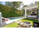 A private backyard oasis with a pool, lush landscaping, and a covered patio for outdoor entertaining at 1781 Pine Ave, Winter Park, FL 32789