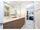 Bright bathroom featuring a double vanity with modern wood cabinets and quartz countertop and a view into another room at 1781 Pine Ave, Winter Park, FL 32789