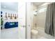 Modern bathroom showcasing a shower-over-tub with a gray shower curtain, with a view into the guitar themed media room at 1781 Pine Ave, Winter Park, FL 32789