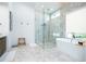Bathroom showcasing a soaking tub, marble floors, and modern fixtures at 1781 Pine Ave, Winter Park, FL 32789