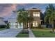 Modern two-story home with a brick and white facade, two-car garage, and a well-manicured lawn at 1781 Pine Ave, Winter Park, FL 32789
