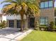 A modern home exterior showcasing a stone facade, a well-manicured lawn, and a large palm tree at 1781 Pine Ave, Winter Park, FL 32789