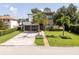 Contemporary home showcasing a two-car garage, and elegant landscaping with a well-manicured lawn at 1781 Pine Ave, Winter Park, FL 32789