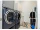 Well-equipped laundry room with modern washer and dryer, white cabinetry, and tiled flooring at 1781 Pine Ave, Winter Park, FL 32789