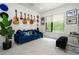 Fun living room area featuring unique décor, a blue sofa, a large window, and space for a keyboard at 1781 Pine Ave, Winter Park, FL 32789