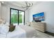 A contemporary bedroom featuring a king bed, light colored walls, and a wall-mounted television at 1781 Pine Ave, Winter Park, FL 32789