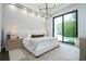 A serene bedroom featuring a king bed, sliding doors to backyard pool area, and an elegant light fixture at 1781 Pine Ave, Winter Park, FL 32789