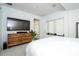 Bright bedroom featuring neutral decor and a wooden dresser beneath a television screen at 1781 Pine Ave, Winter Park, FL 32789