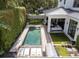 Aerial view of a modern backyard featuring a pool, lounge area, and a covered patio with ample seating space at 1781 Pine Ave, Winter Park, FL 32789