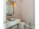 Stylish powder room with unique wallpaper, modern vanity, and elegant lighting fixtures at 1781 Pine Ave, Winter Park, FL 32789
