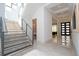Elegant staircase with glass railings leading to the upper level and an open entryway at 1781 Pine Ave, Winter Park, FL 32789
