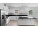 Modern kitchen with sleek white cabinetry, black countertops, an island, and stainless steel appliances at 1812 Stoneywood Way, Apopka, FL 32712