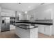 Modern kitchen featuring white cabinets, stainless steel appliances, and a stylish black countertop island at 1812 Stoneywood Way, Apopka, FL 32712