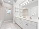 Bathroom with double sink vanity, tile floors, and natural lighting at 19562 Majestic St, Orlando, FL 32833