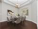 Formal dining room featuring a modern chandelier, large window, and seating for eight at 19562 Majestic St, Orlando, FL 32833