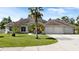 Charming single-story home with a well-manicured lawn, mature palm trees, and a three-car garage at 19562 Majestic St, Orlando, FL 32833