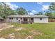 Spacious backyard featuring a covered patio, chicken coop and perimeter fencing at 2105 Ne 50Th Pl, Ocala, FL 34479