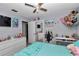 Bright bedroom featuring a ceiling fan, soft blue comforter, and a variety of decorative elements at 2105 Ne 50Th Pl, Ocala, FL 34479