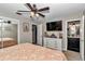 Brightly lit bedroom with a ceiling fan, decorative furnishings, and an ensuite bathroom at 2105 Ne 50Th Pl, Ocala, FL 34479