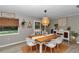 Bright dining room with wood floors, stylish light fixture, and modern white chairs at 2105 Ne 50Th Pl, Ocala, FL 34479