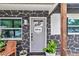 Close-up of the gray front door with decorative stone accents and a 'Welcome' sign at 2105 Ne 50Th Pl, Ocala, FL 34479