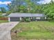 Charming single-story home featuring a metal roof, well-manicured lawn, and a welcoming gray front door at 2105 Ne 50Th Pl, Ocala, FL 34479