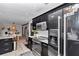 Stylish kitchen with stainless steel appliances, dark cabinets, granite countertops, and dining area views at 2105 Ne 50Th Pl, Ocala, FL 34479