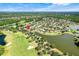 Aerial view of a community with homes surrounding a golf course and several lakes at 217 Lake Cassidy Dr, Kissimmee, FL 34759