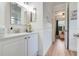 Well-lit bathroom with a pristine white vanity, modern fixtures, and adjacent doorway to bedroom at 217 Lake Cassidy Dr, Kissimmee, FL 34759