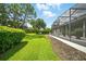 Beautifully maintained lawn with lush greenery bordering the screened-in porch at 2308 Bur Oak Ct, Oviedo, FL 32766