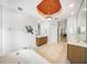 Bright bathroom with dual sinks, soaking tub, artistic ceiling, and a decorative crustacean wall hanging at 2308 Bur Oak Ct, Oviedo, FL 32766