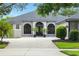 Close up view of a one story home with an arched entry and paver driveway at 2308 Bur Oak Ct, Oviedo, FL 32766