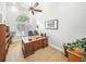 Bright home office featuring a large wooden desk, arched window with shutters, and ceiling fan at 2308 Bur Oak Ct, Oviedo, FL 32766