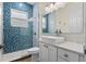 Bathroom featuring blue mosaic tile, walk-in shower, floating vanity and chrome fixtures at 2456 Northumbria Dr, Sanford, FL 32771